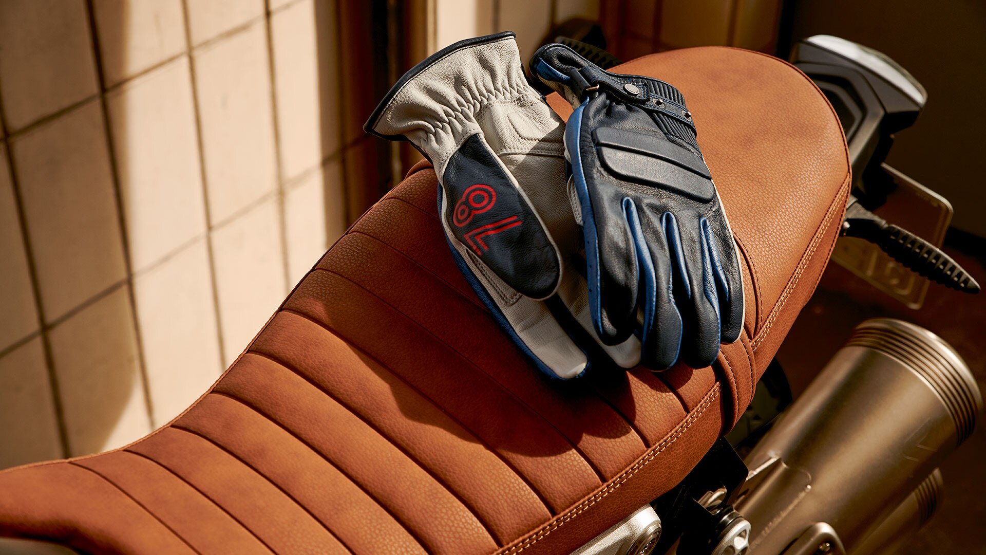 Leather gloves “40 Ans“ Edition Limiteé, based on the Rockster gloves lying on a motorcycle seat